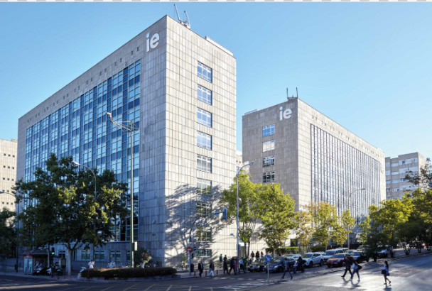Edificio del campus con estudiantes en la plaza de entrada